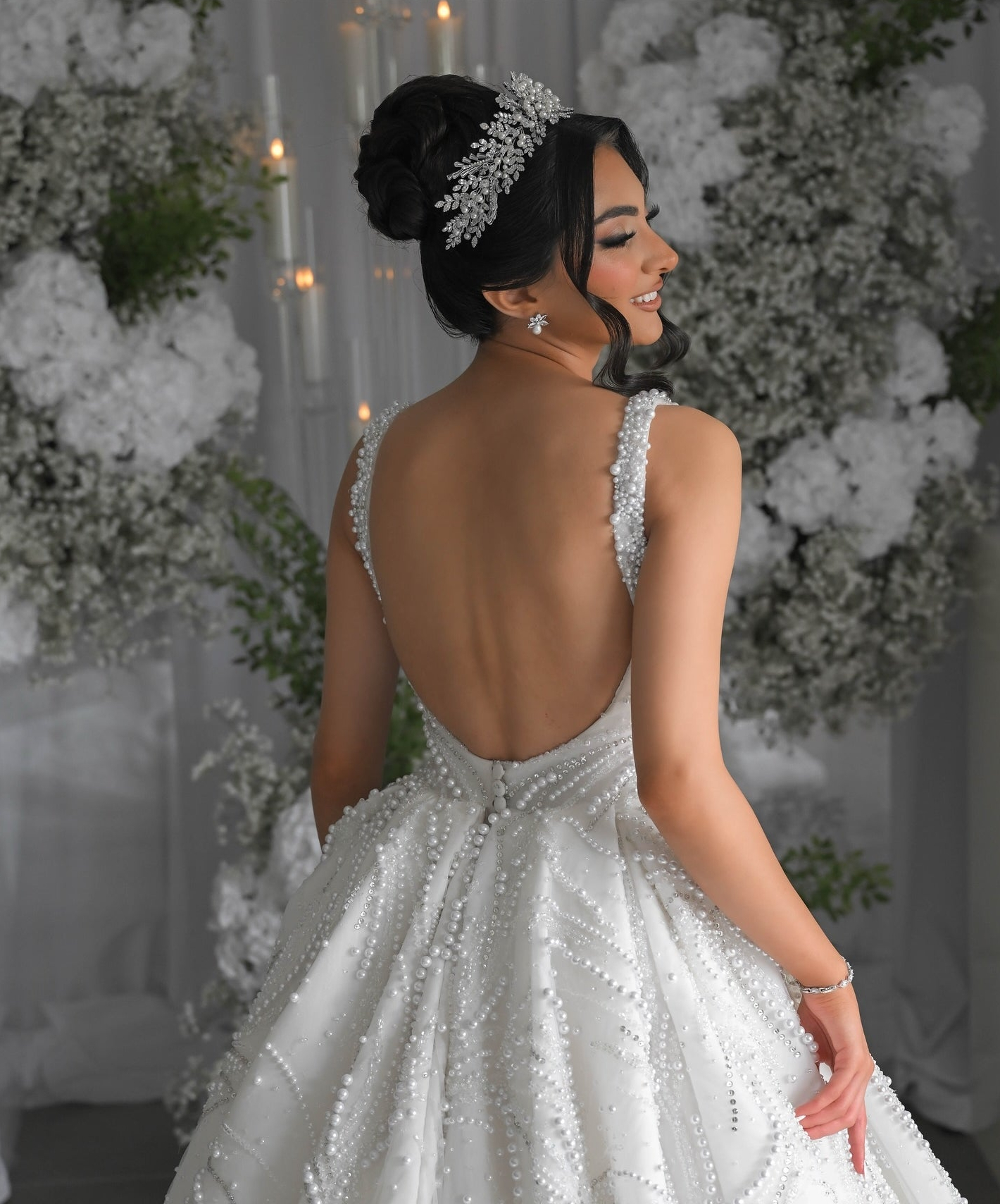 Bride wearing an intricate silver and pearl headpiece with a pearl-beaded wedding dress